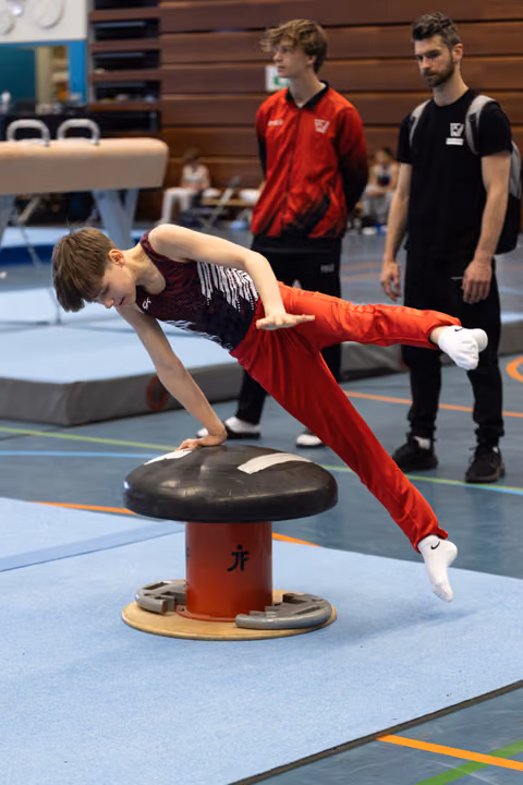 Young athlete demonstrates impressive strength on mushroom circle apparatus while coaches observe during training session