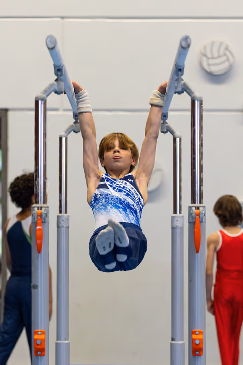 Athlete performs vertical hold on parallel bars with arms extended overhead, displaying strength and control during routine