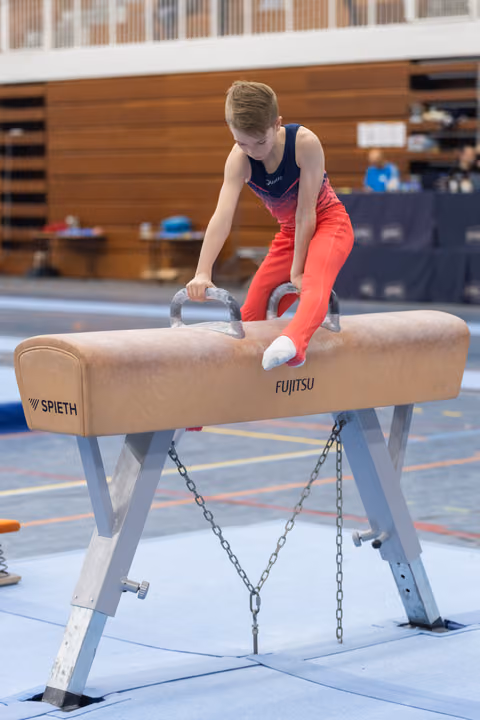 Young gymnast in gradient leotard executes a move on the pommel horse, demonstrating focus and control in the gym.