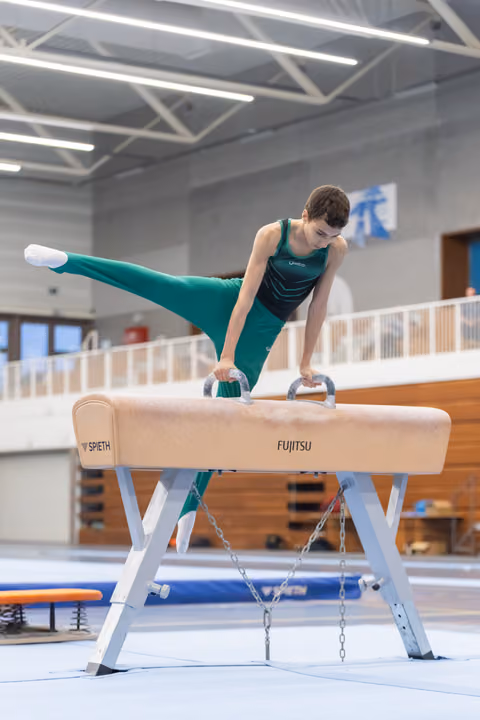 Young gymnast executing a horizontal split handstand on pommel horse, demonstrating strength and control in training facility