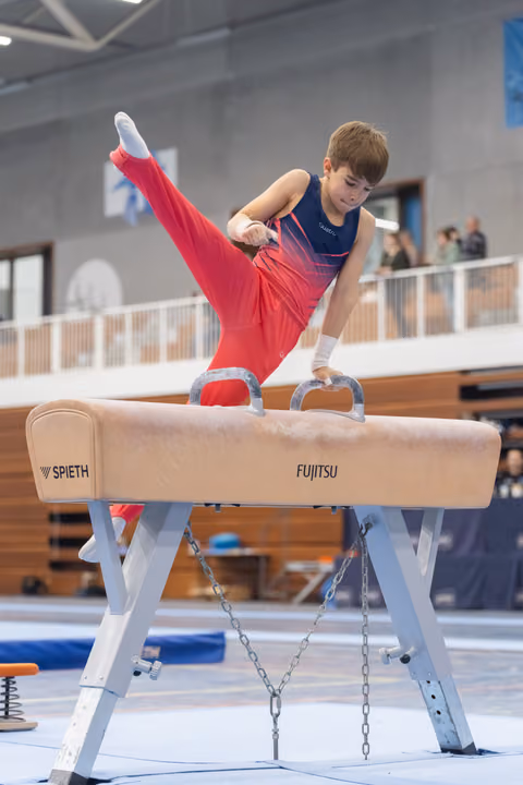 Young gymnast performs a leg extension on pommel horse, demonstrating strength and flexibility in a training facility
