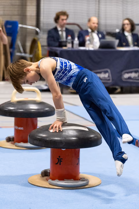 Young gymnast performing circles on mushroom apparatus with intense concentration while judges observe in background